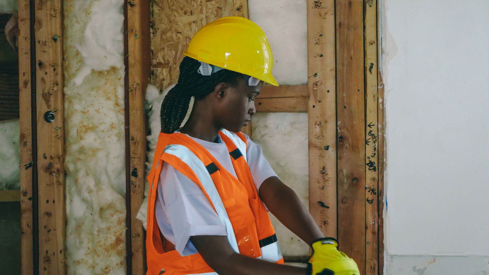 Female construction worker using hand tools during interior construction work.